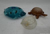 Group view of three glass turtle paperweights