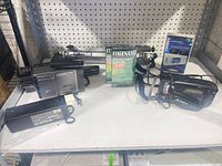 Overall lot showing both camcorders, tripod, sealed tapes, cleaner