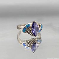 Sterling silver ring featuring marquise tanzanite center and blue opal inlay shoulders