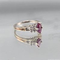 Top view of sterling silver ring with marquise ruby centre and clear side stones