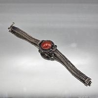 Full view of bracelet showing woven strands and carnelian center