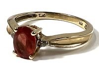 Ring angled view showing fire opal, diamond accents, split shank, and 14K stamp