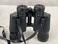 Front angled view of binoculars showing body texture, strap and eyepieces