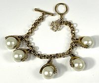 Full view of bracelet showing five faux pearl charms and toggle clasp