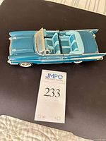 Left side view of blue/teal 1957 Chevrolet Bel Air convertible model with doors closed