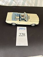 Passenger side view of cream 1:18 Ford Mustang convertible model