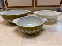 Three Pyrex Crazy Daisy bowls front and side view showing pattern and colour