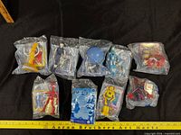 Nine sealed Robots Burger King toys laid out for overview