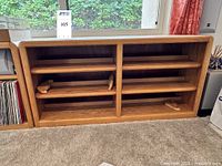 Front view of oak CD/DVD shelving unit with six shelf positions and bookends