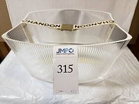 Front view of clear ribbed acrylic ice bucket showing CHANDON strap handle