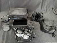 Overview of Garmin GPS unit with accessories and Vivitar binoculars