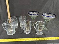 All seven glasses lined up with rulers for scale