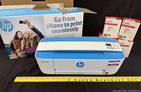 Printer, original box, four ink cartridge boxes shown with ruler for scale