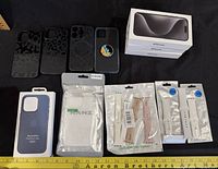 Group shot showing three iPhone boxes, six phone cases and five watch-band packages