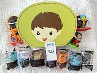 Front view showing lunchbox lid, three premium toys on stands, six sealed Kidrobot blind bags