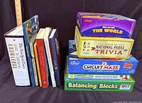 Stack of seven books next to four boxed games