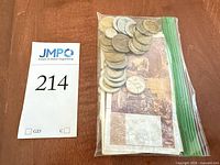 Bagged lot showing stack of banknotes and pile of coins