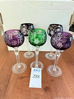 Front view of five colored cut-to-clear crystal wine glasses