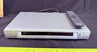 Front view of Sony DVD/CD player with remote placed on top