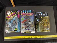 Front view of the three sealed Spawn figures showing character names and packaging wear