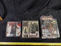 Front view of all three sealed Spawn figures showing titles and worn packaging