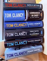 Stack of six Tom Clancy hardcover novels showing spines and titles