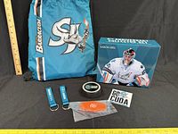 Full lot view showing backpack, bobblehead box, puck, keychains, accessory, sticker