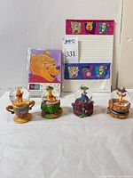 Four Winnie the Pooh mini snowglobes and Pooh stationery set overview