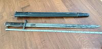 Bayonet and scabbard laid out with ruler for scale