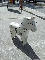 Front-left view of white wooden Dala horse with symbols and eyeglasses