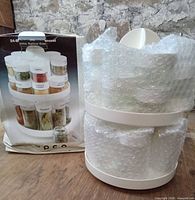 carousel and jars wrapped in bubble wrap beside product box front graphic