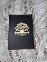 Front cover showing title and gold emblem on black cloth binding