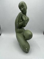 Full front-left view of matte green chalkware kneeling nude sculpture showing overall form and paint loss