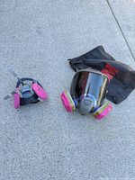 Full-face and half-mask respirators with filters and storage bag on concrete