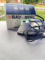 Iron with coiled cord in front of original box