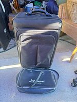 Front view of suitcase standing with tote bag at base