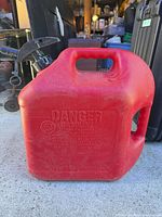 Full view of red Blitz 5-gal gas can with spout attached