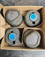 Top view of four felt-covered speaker housings in box