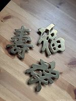 All three brass Chinese character plaques on tabletop