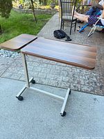 Full view of table showing split top and castered base