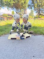 Front view of dual-player figurine on outdoor surface