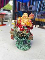 Front view of multicolor resin Laughing Buddha on dragon base