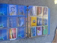 Open binder showing multiple pages of assorted NTT phone cards in clear sleeves