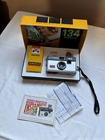 Camera, film cartridge and paperwork inside original box