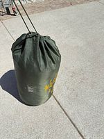 Sleeping bag packed in olive green stuff sack, full view
