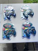 Four sealed handheld games on table, two labelled Electronic Hockey, two Electronic Basketball