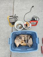 Lot overview showing both work lights, two buckets of hardware and blue tote with rags