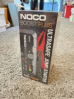 Front view of sealed NOCO Boost Plus GB40 box displaying UltraSafe Jump Starter and 12V 1000A specs