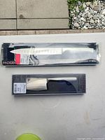 Two sealed Paderno knife packages on table