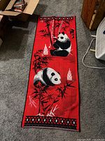 Full view of red panda bamboo tapestry on floor